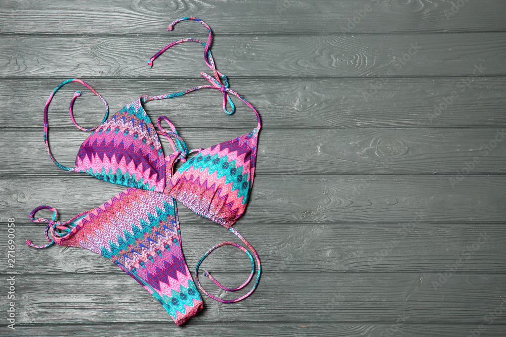 Stylish bikini on wooden background, flat lay. Space for text Stylish bikini on wooden background, flat lay. Space for text
