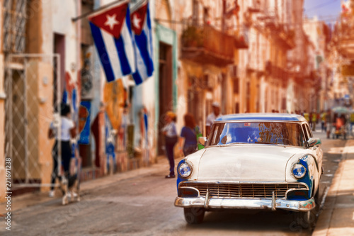 Cuban flags,old car and decaying buildings in Havana