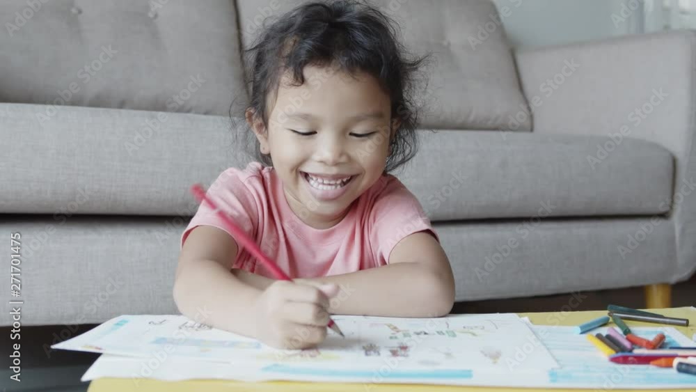 Asian girl wearing casual dresses are drawing and smiling happily at home. Asian girl wearing casual dresses are drawing and smiling happily at home.