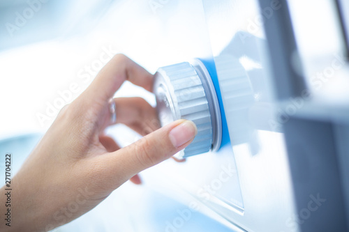 Close up hand is turning dial knob of laundry washing machine