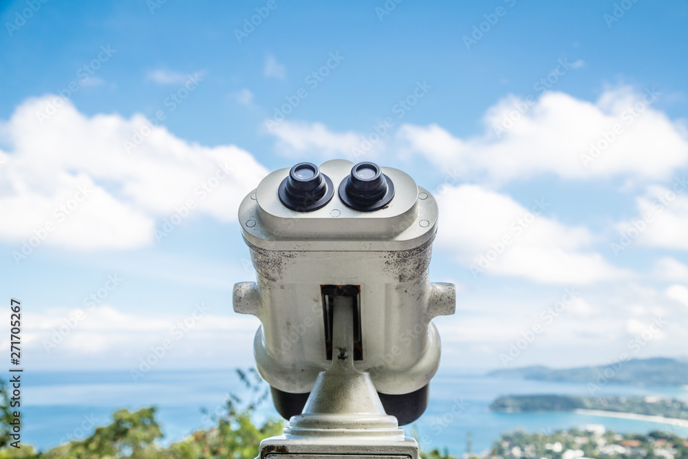 Coin Operated Binocular viewer next to the waterside promenade in Phuket looking out to the Bay. Landscape with beautiful cloudy sky and sea