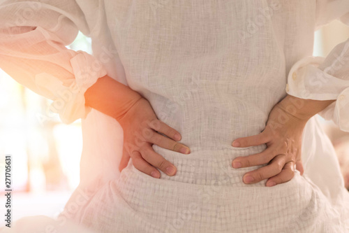 Back pain in woman concept. Female patient hurt from lower backache from bowel and bladder problems, palvic inflammatory disease (PID) or motherhood pregnancy.