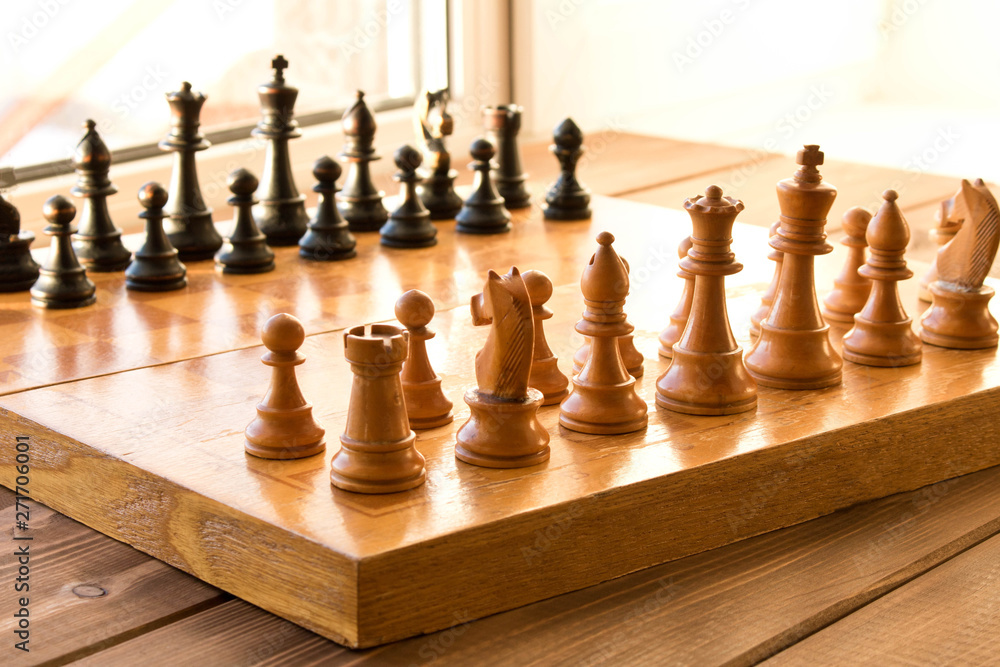 Chessboard with figures on a wooden table. Selective focus. Chessboard with figures on a wooden table. Selective focus.