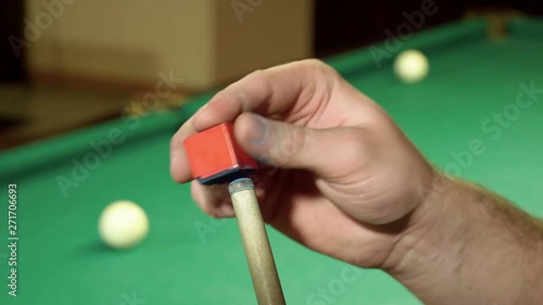 Game of billiards. Close-up shot of billiard player rubbing the snooker cue with chalk. 4K