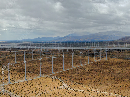 Aerial view of wind turbines generating electricity. Huge array of gigantic wind turbines spreading over the desert in Palm Springs wind farm, California, USA  © Unwind