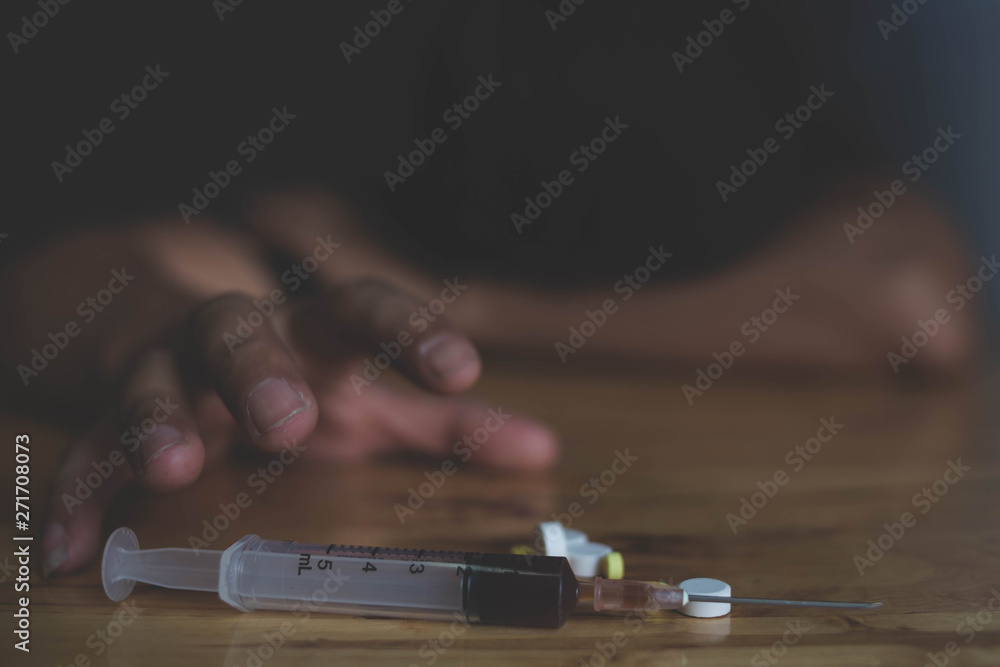 Addict man grab drug syringe of heroin.