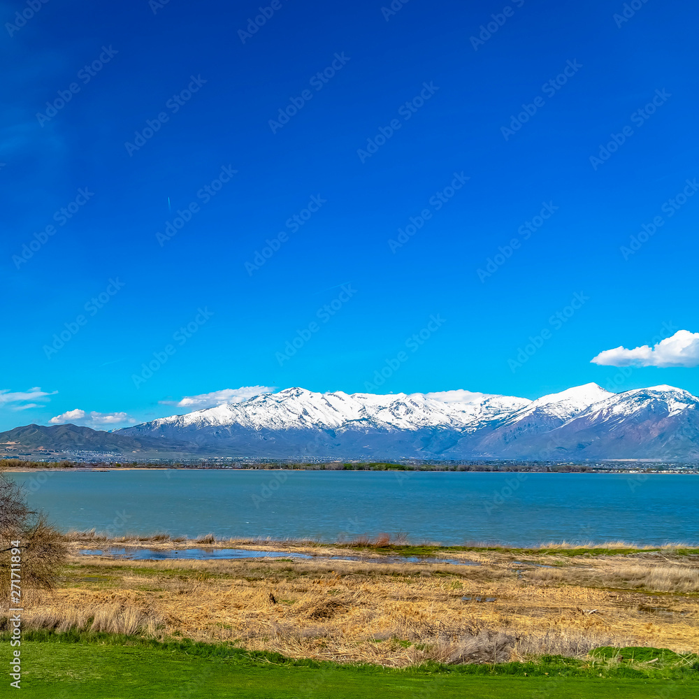 Frame Square Panorama of a calm lake and mountain with snowy peak under vivid blue sky
