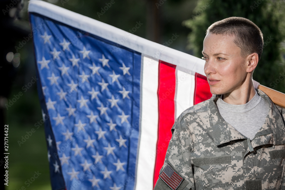 Beautiful american soldier in uniform standing in front of american flag Beautiful american soldier in uniform standing in front of american flag