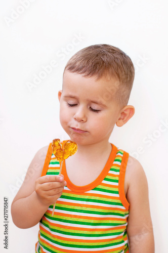Beautiful two year old boy looking at lollypop