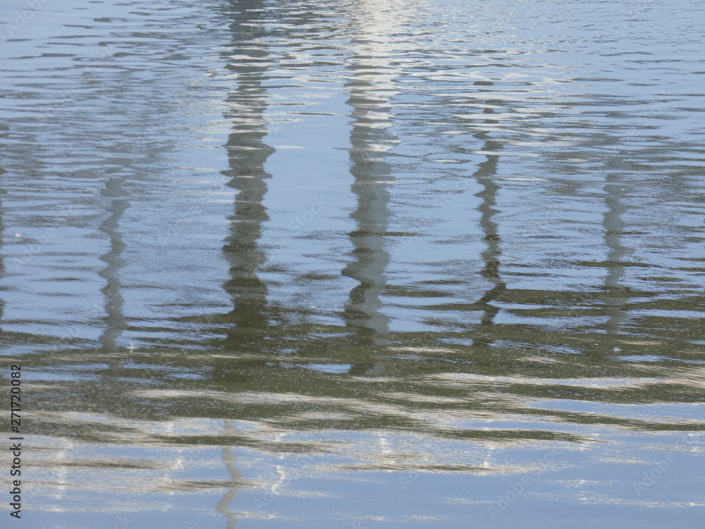 Fototapeta premium Reflejos en el agua de un río, reflejo de un puente moderno