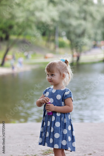 Adorable little girl blowing bubble.