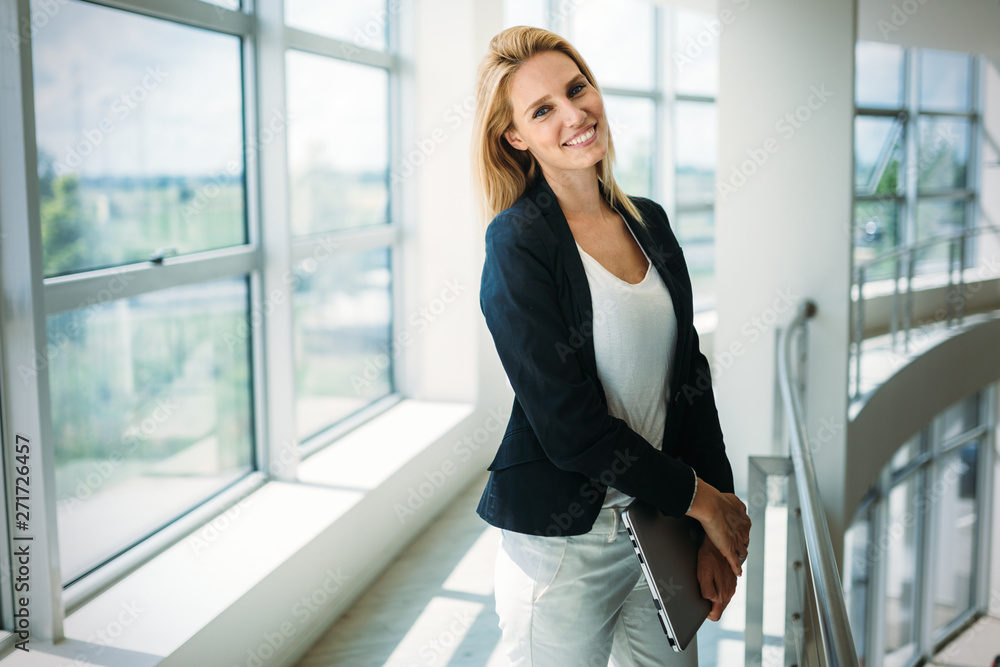 Portrait of young busineswoman standing in office lobby. Portrait of young busineswoman standing in office lobby.