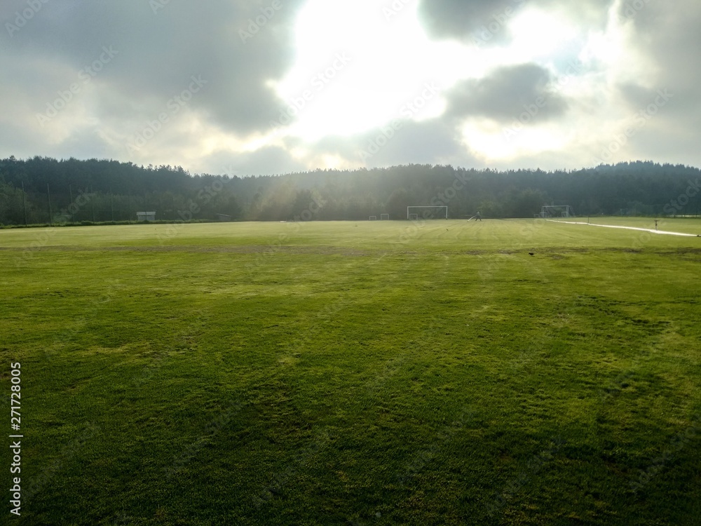 grass football field in sunny day with clouds grass football field in sunny day with clouds