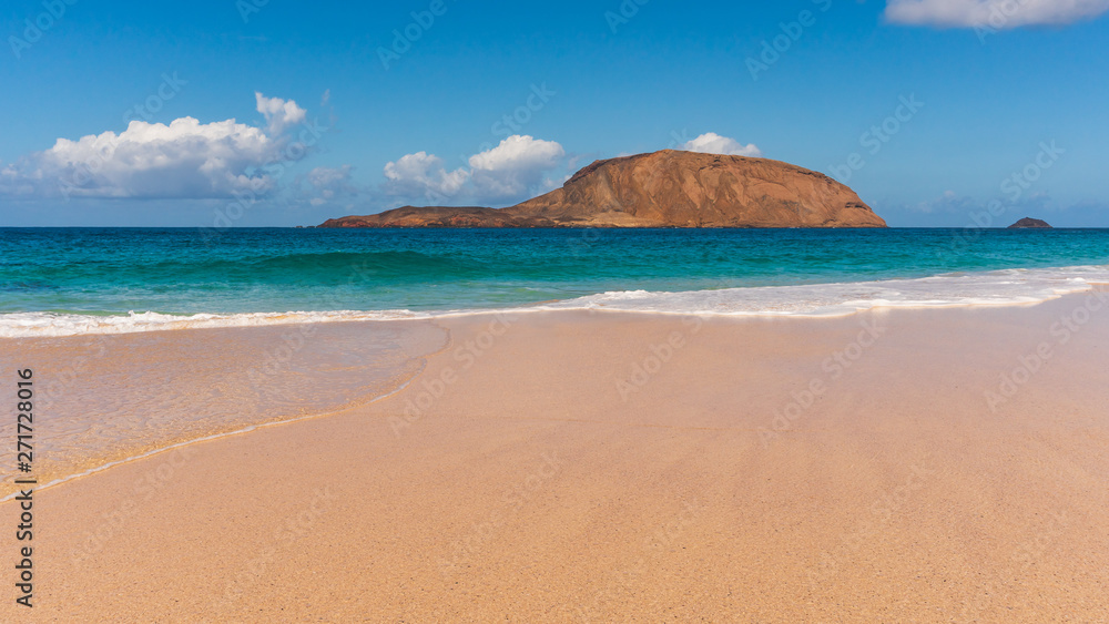 Amazing beach with untouched sand and turquoise waters on a sunny summer day landscape. La Conchas beach (Playa de las Conchas) on La Graciosa Island, Canary, Spain.