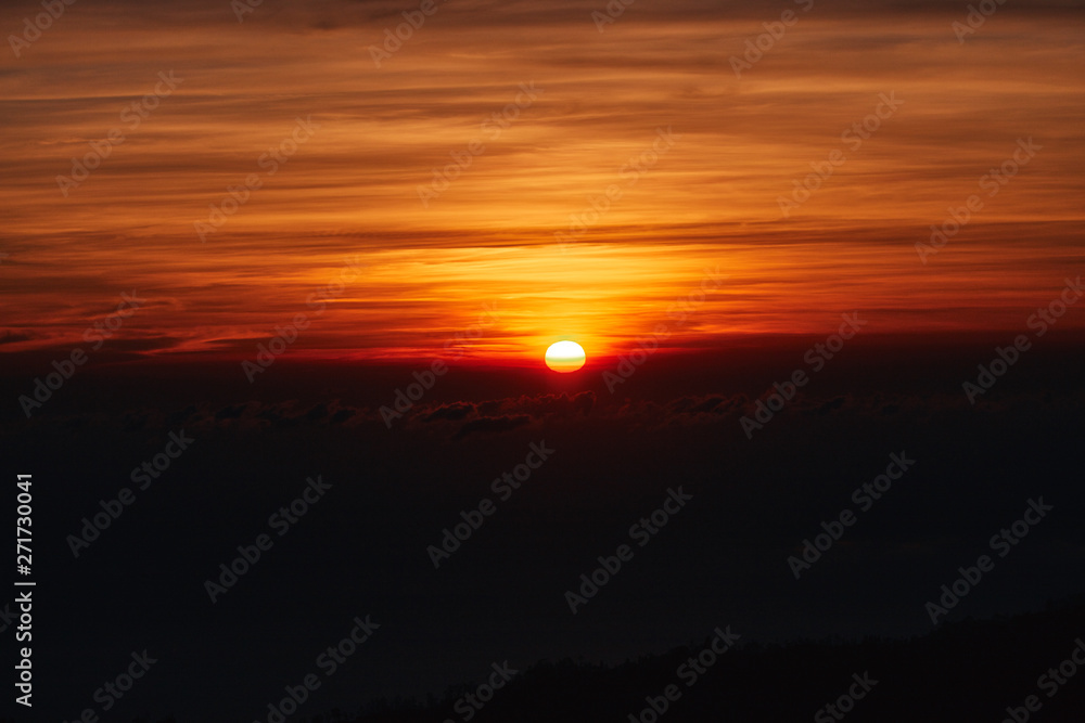 Sunrise / sunset over the clouds and horizon in golden colors.