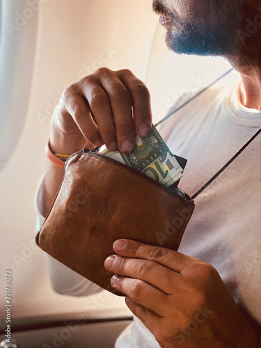 Airplane passenger with a neck bag for safe carrying money and documents. photo