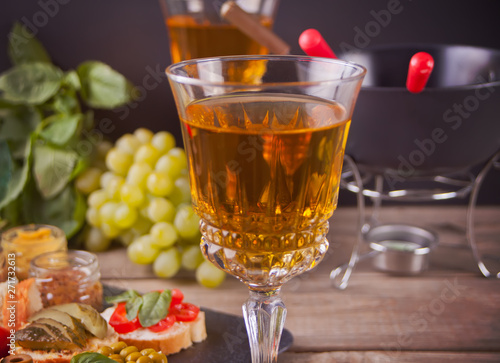 Italian bruschetta in assortment on the plate, glasses with white wine, grapes, fondue. Party or dinner concept.