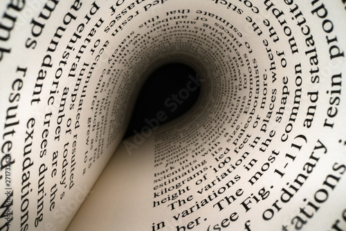 Inside the book concept. Latin letters and words on an tunnel shaped, perspective book page with black dramatic light. Education, knowledge concept