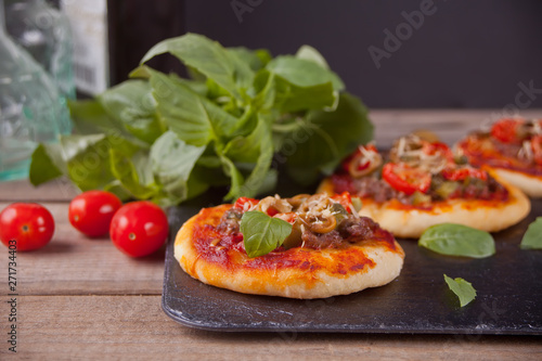 Homemade mini pizza on the black plate.