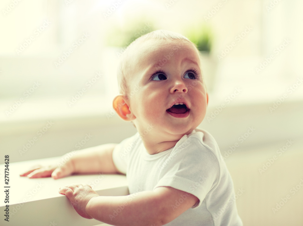 childhood, babyhood, emotions and people concept - close up of happy little baby boy or girl at home childhood, babyhood, emotions and people concept - close up of happy little baby boy or girl at home