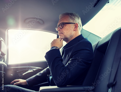 transport, business trip and people concept - senior businessman driving on car back seat