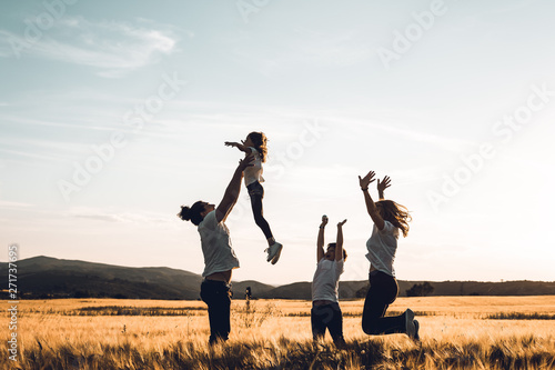 Father throws his little girl in the air. Happy family in the countryside having fun