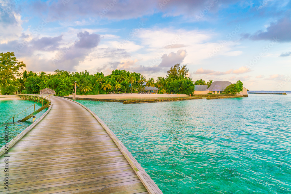 Beautiful water villas in tropical Maldives island at the sunset time .