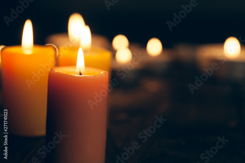 candles burning in darkness over black background. commemoration concept. photo