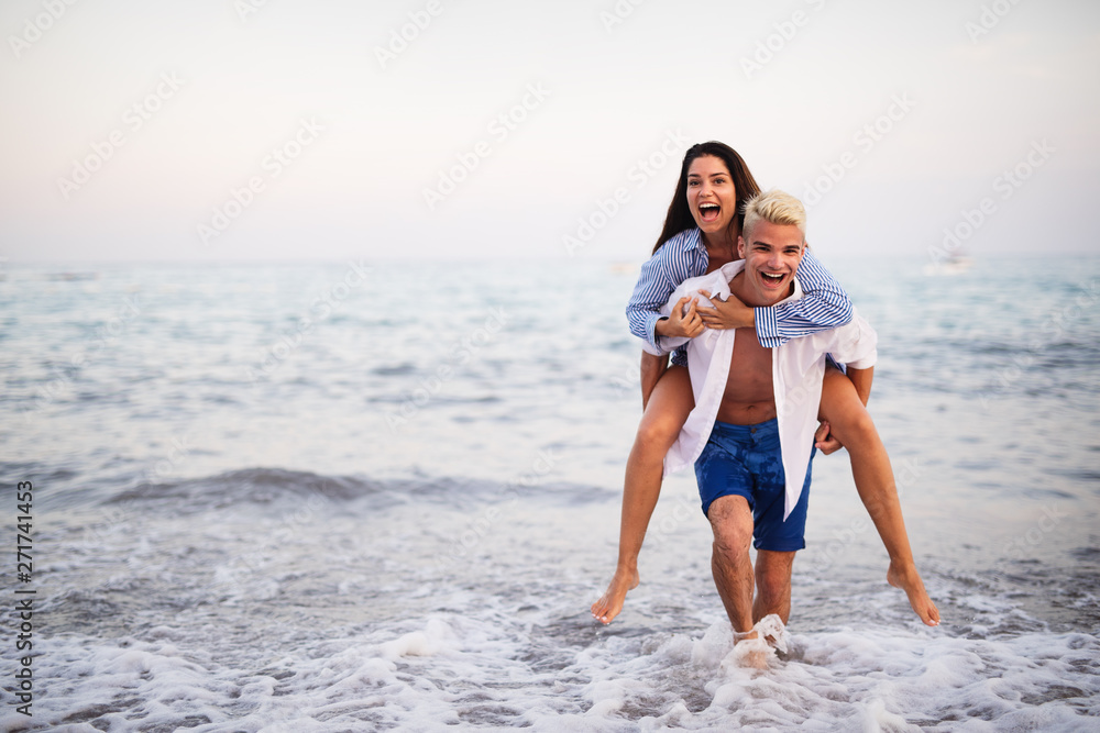 Happy young couple having fun and love on the beach