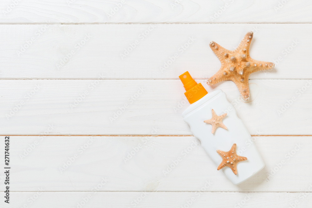 flat lay concept summer travel vacation. Sunscreen bottles with starfish on white wooden table with copy space