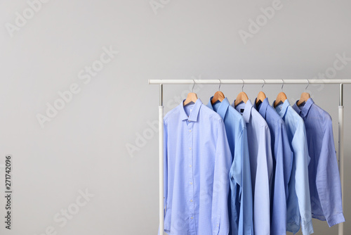 Rack with clothes after dry-cleaning on light background © Pixel-Shot