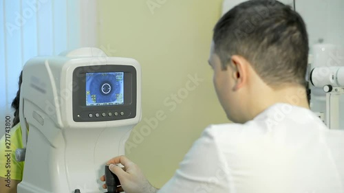 Doctor ophthalmologist working with patient in office. Examining her eyes on special equipment. photo