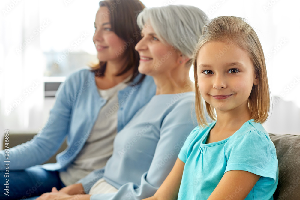 family, generation and female concept - portrait of smiling mother, daughter and grandmother sitting on sofa at home family, generation and female concept - portrait of smiling mother, daughter and grandmother sitting on sofa at home