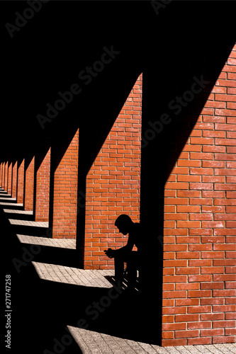 The silhouette of a man sitting on a bench in the loft