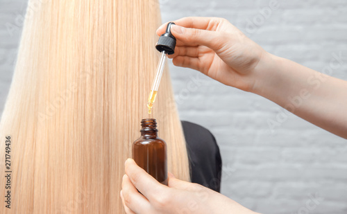 Master hairdresser procedure oil hair treatment for woman. Concept spa salon.