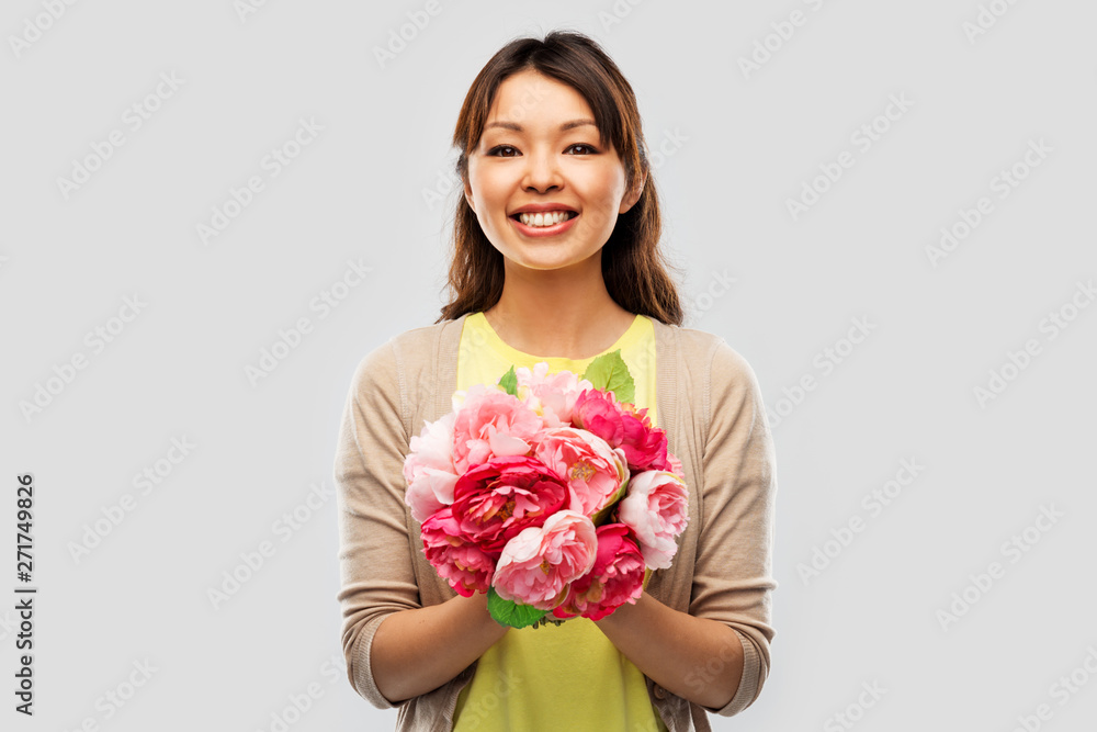 people and international women's day concept - happy asian young woman with bunch of peony flowers over grey background people and international women's day concept - happy asian young woman with bunch of peony flowers over grey background