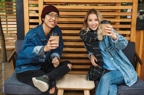 Smiling multhiethnic couple sititng at the cafe outdoors photo