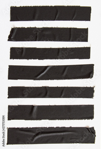 фотографія Crumpled pieces of black matte cloth gaffer tape on white paper background