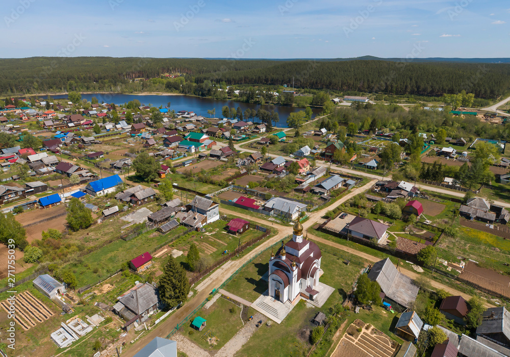 Church in Kamenka village surrounded by forest, Sunny day, summer, Aerial