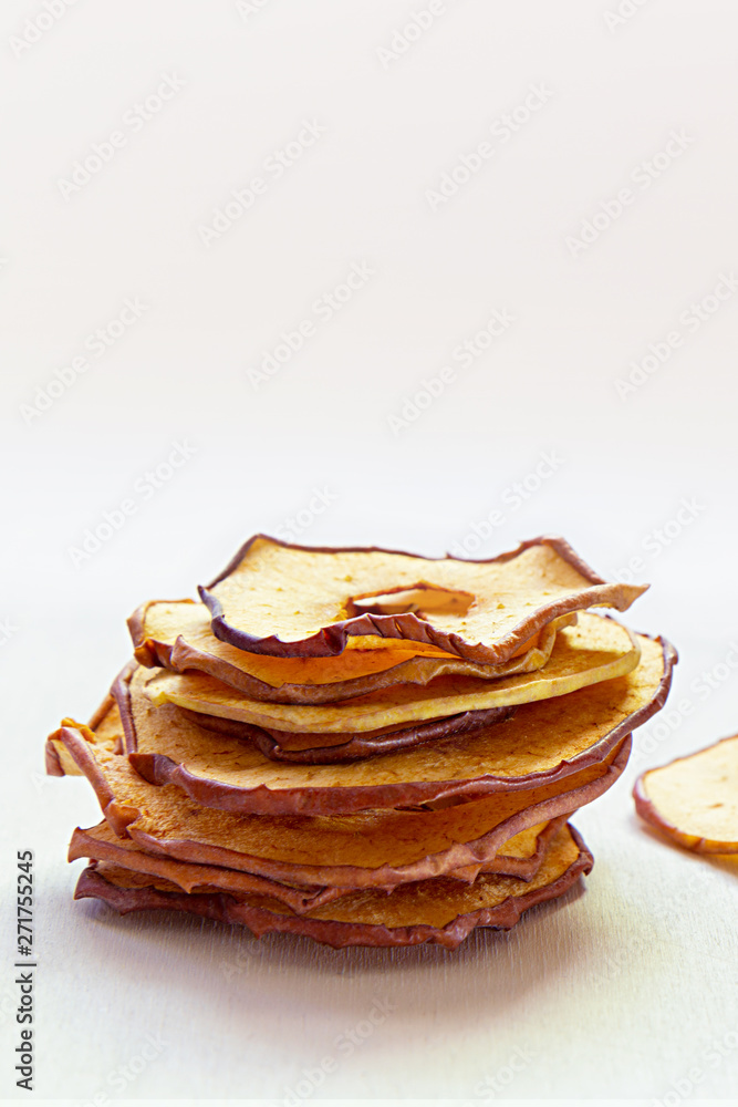 Dried dehydrated apple chips on white wooden table. Healthy vegan snack. Vertical, copy space. Dried dehydrated apple chips on white wooden table. Healthy vegan snack. Vertical, copy space.
