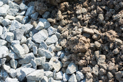 Background of crushed stone and soil against a sun in a pile. Materials for road construction