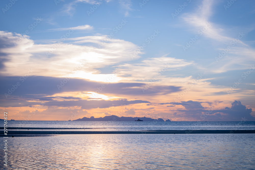 Beautiful beach sunset with blue sea and golden light sky  cloud background