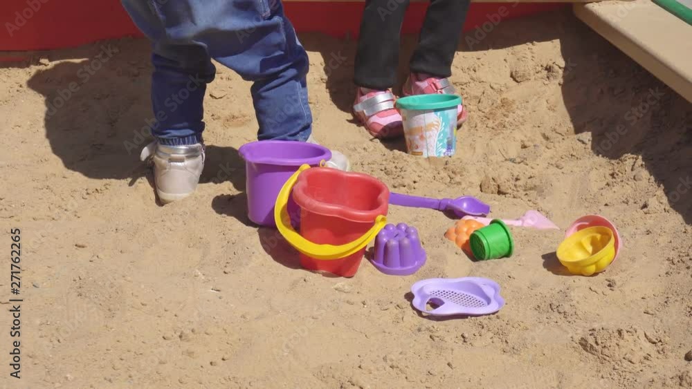 Young children playing with mom on the playground in the sandbox, amusement, activity Young children playing with mom on the playground in the sandbox, amusement, activity
