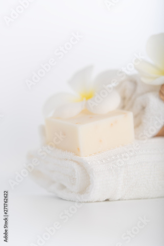 White towels organic soap and Plumeria flower over white background spa concept