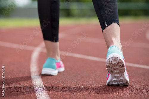 Young fitness woman legs running at morning on treadmill.Athletic woman feet on running track, close up on shoe.Woman wear sport shoe on to run in running court background. Health exercise life style 