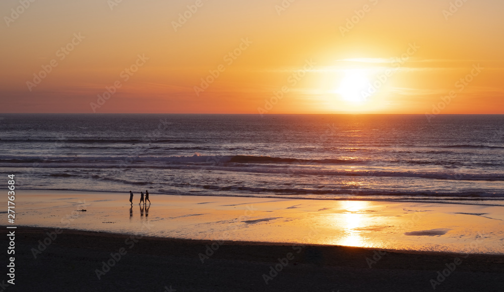 Friends walking on the beach at sunset, San Sebastian