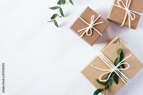 Craft gift boxes on white wooden background. Copy space for text. Eco concept