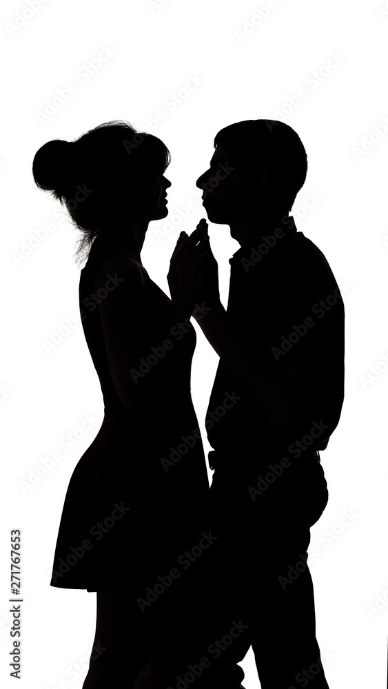 silhouette of a young male and female in love on white isolated background, man touch hands of woman and dancing slowly, concept romance