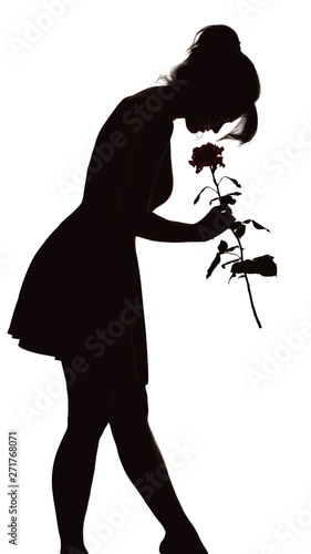 Tableau sur toile silhouette of a young elegant woman in a dress tilted his head to the bud of ros