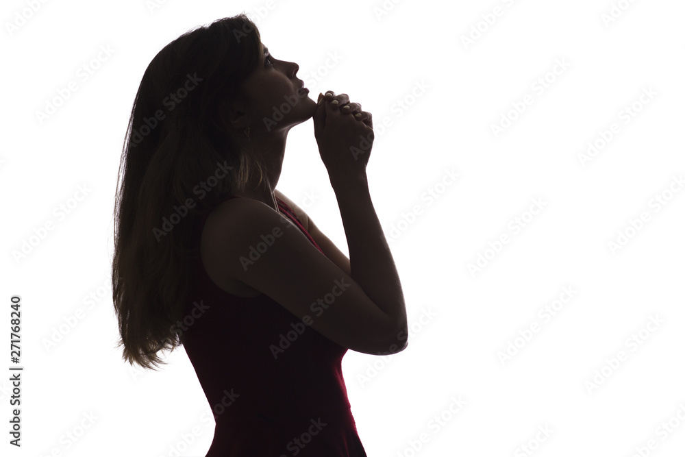 silhouette profile of a girl with a folded hand on her chin and looking upwards, a pensive young woman on an isolated background, concept of religion and life